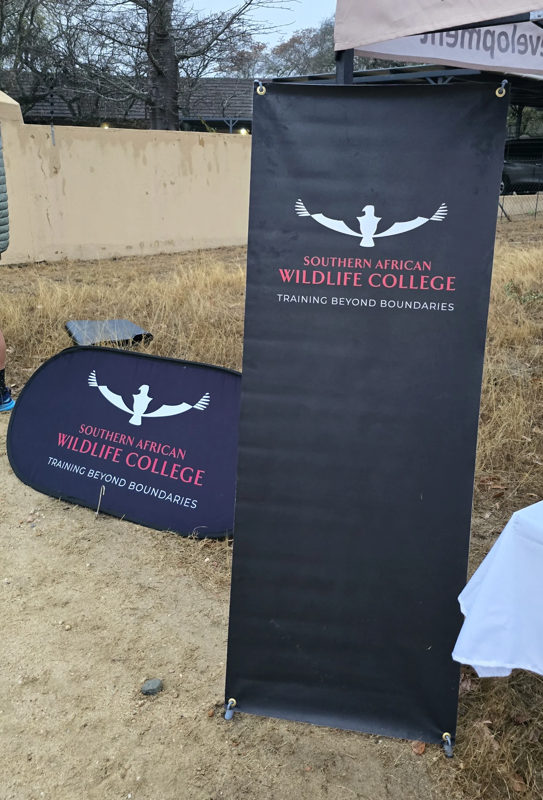 An X-banner and pop-up banner alongside each other at an event for the Southern African Wildlife College.