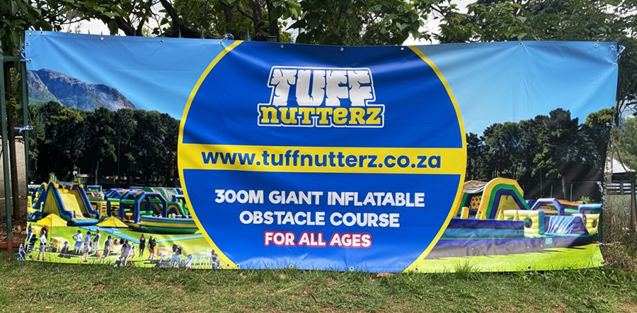 A fence banner printed for Tuff Nutterz by Brand Monster, attached to a fence.
